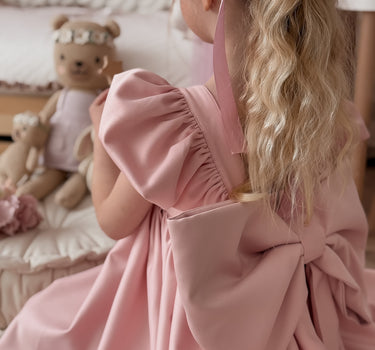 Side angle of blush satin puff sleeve girl dress