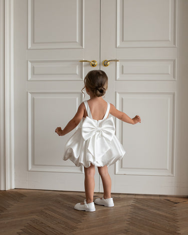 toddler twirling in the Bella Bow white bubble skirt dress