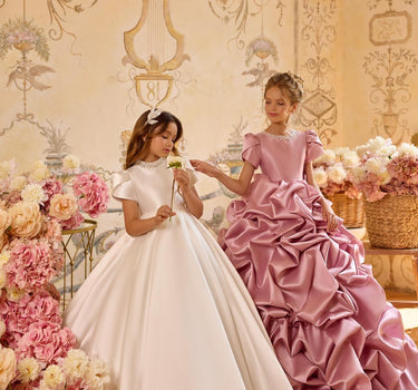 Child posing in Isabella handmade gown at an indoor gold themed photoshoot