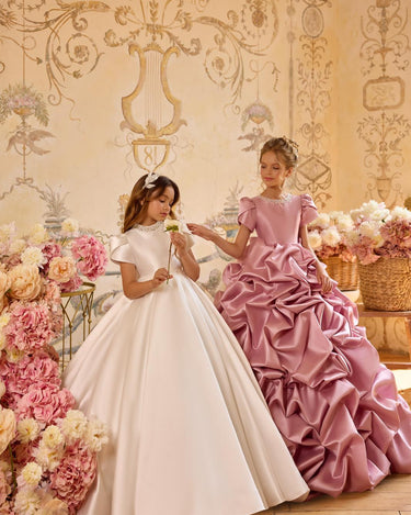 Child posing in Isabella handmade gown at an indoor gold themed photoshoot