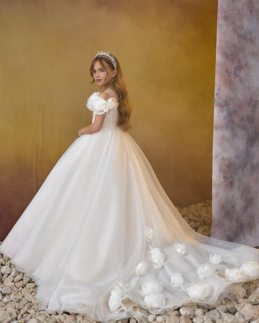Little girl wearing the Maison luxury sparkly off shoulder flower girl gown with full skirt and train