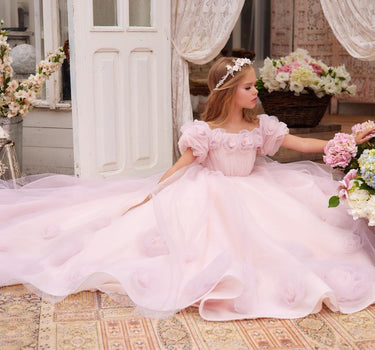Little girl wearing a blush pink handmade floral princess gown with full tulle skirt.