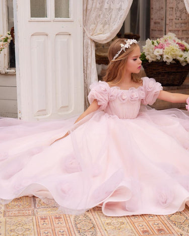 Little girl wearing a blush pink handmade floral princess gown with full tulle skirt.