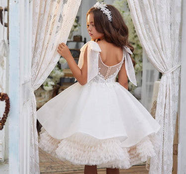 Girl wearing the Elara Dress looking out a window, showing layered tulle skirt