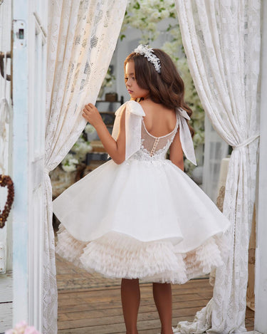 Girl wearing the Elara Dress looking out a window, showing layered tulle skirt