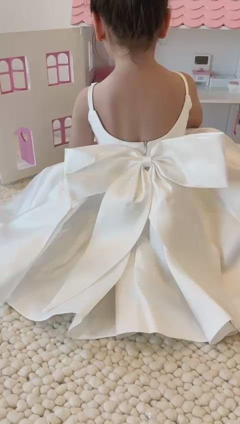 Little girl at an event wearing the Majestic Mikado Dress in white with a large satin bow video
